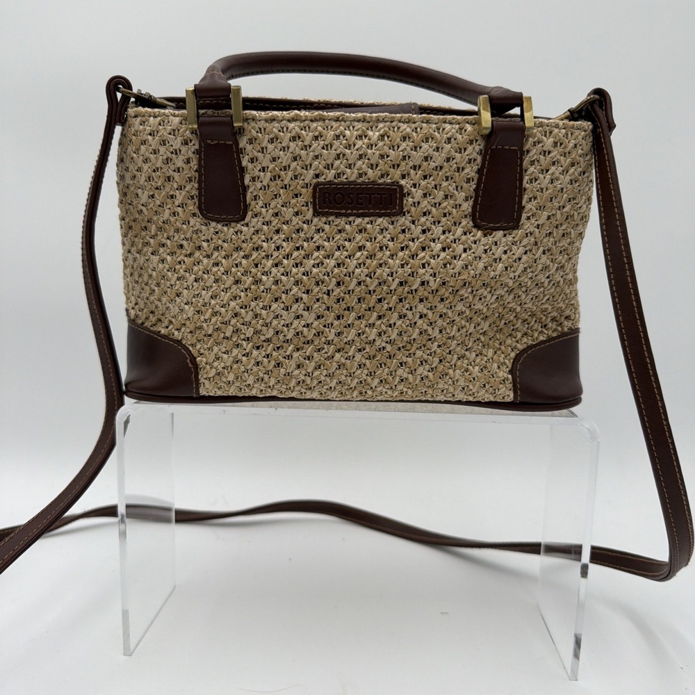 Rosetti straw tote handbag with brown faux leather trim and top handles.